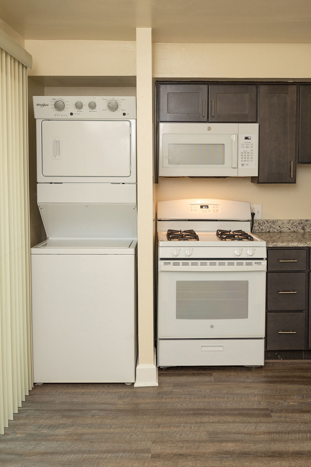 A white dishwasher is next to a white oven and microwave in a kitchen.