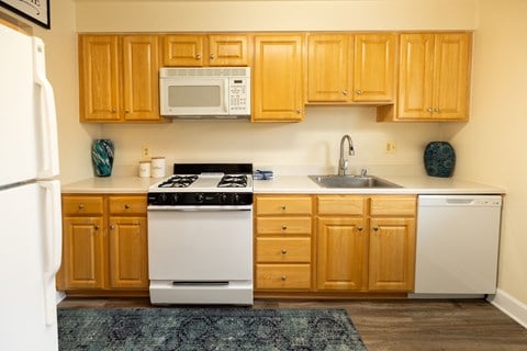 a kitchen with white appliances and wooden cabinets