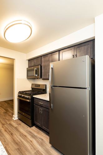 a kitchen with dark wood cabinets and stainless steel appliances
