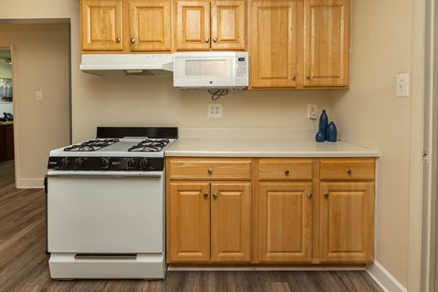 A kitchen with wooden cabinets and a white stove.