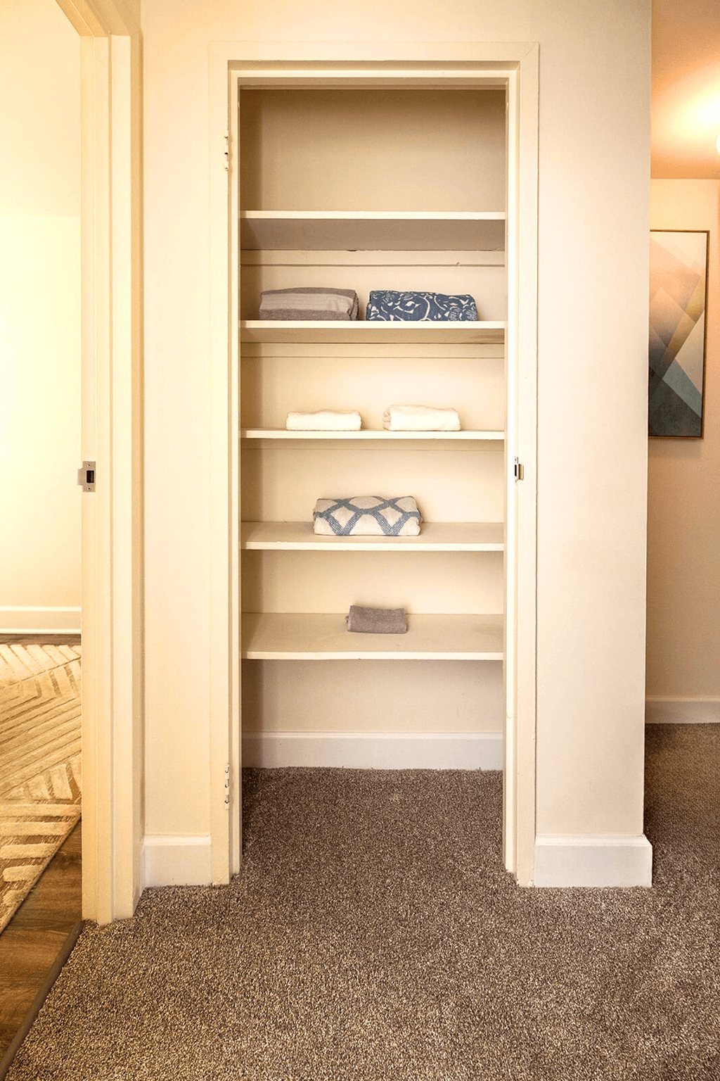 A white closet with shelves and towels.