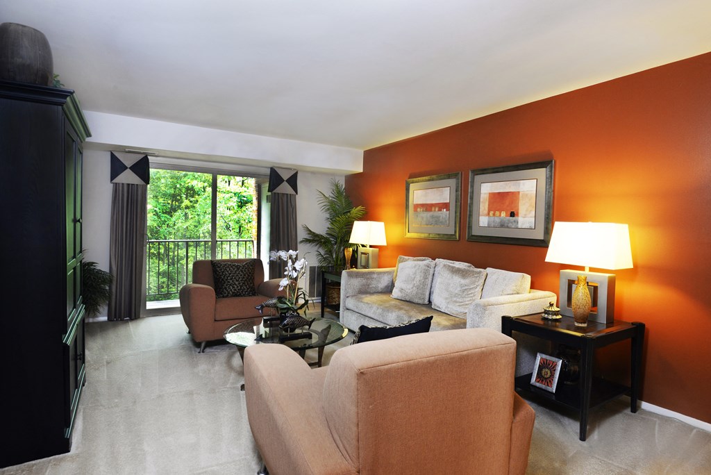 a living room filled with furniture and a large window at Liberty Gardens Apartments, Baltimore, 21244