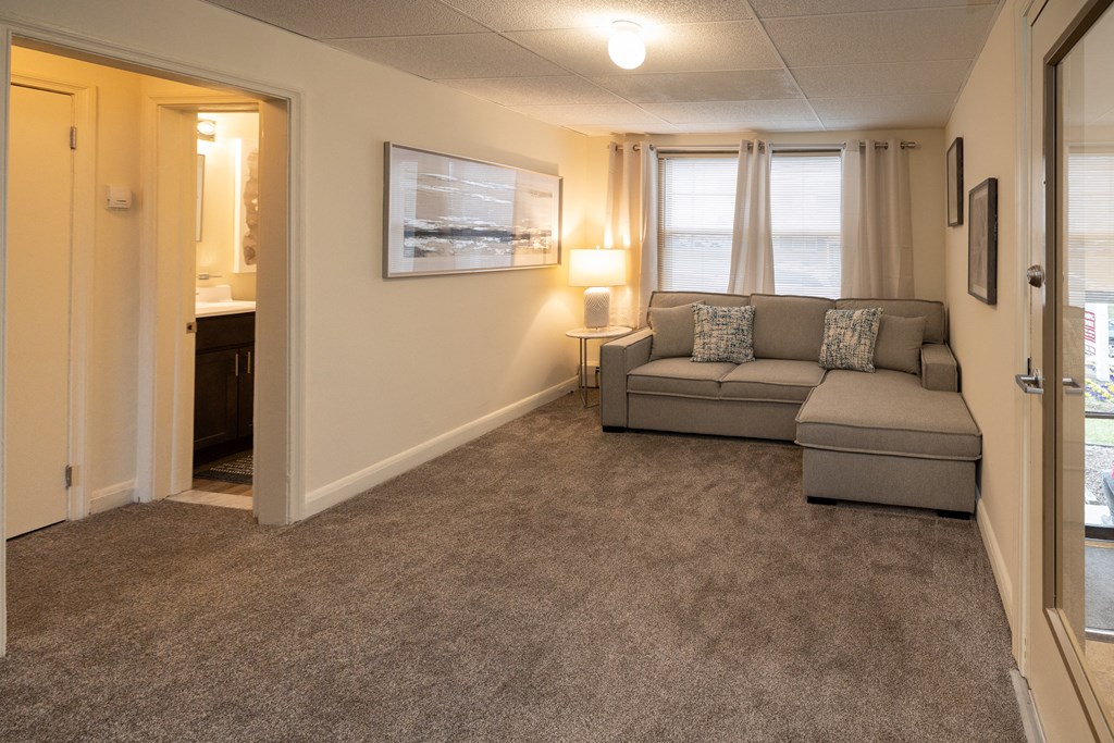 a living room with a couch and a door to a bathroom