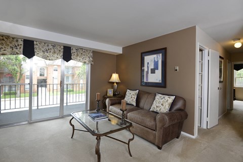 Living room with a couch and a table at Painters Mill Apartments, Randallstown, MD, 21117