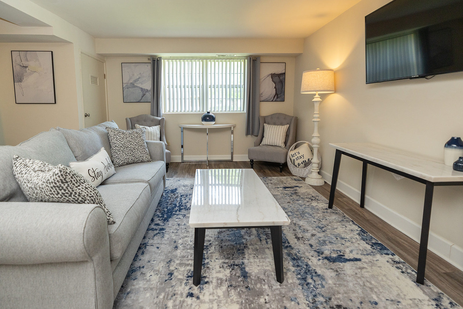A living room with a grey couch and a white coffee table.