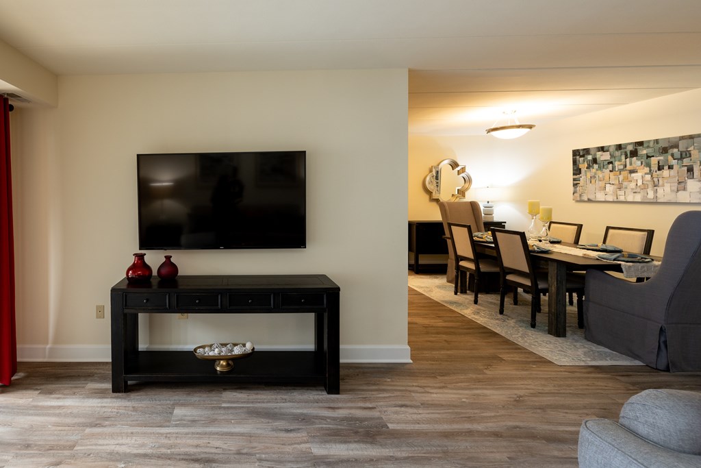 A black coffee table with a TV above it and a red vase on it  at Ivy Hall Apartments*, Maryland, 21204