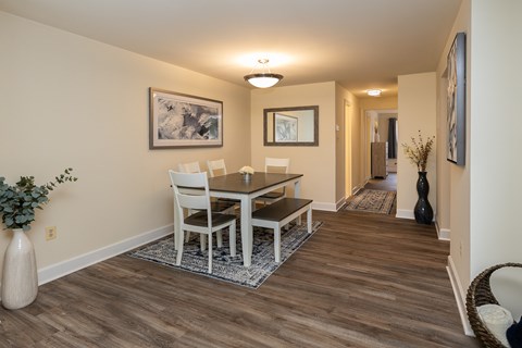 A dining room with a table and chairs.