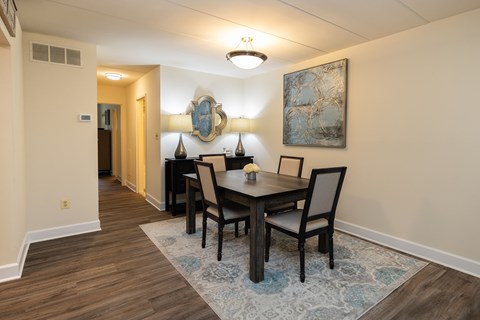 A dining room with a table set for four.