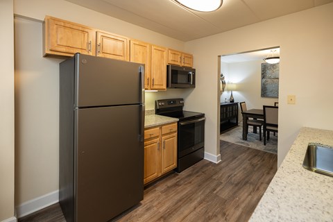 A kitchen with wooden cabinets and a granite countertop  at Ivy Hall Apartments*, Maryland, 21204