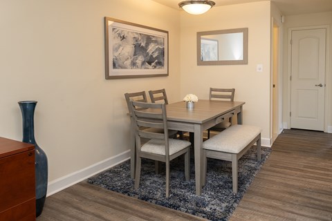 A dining room with a table and chairs.