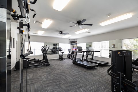A gym with treadmills, elliptical machines, and other exercise equipment.