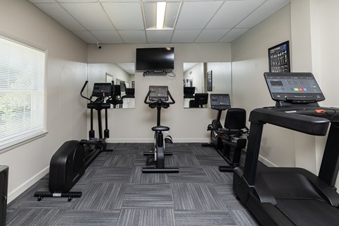 A gym with treadmills and elliptical machines.