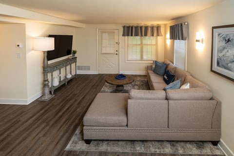 A living room with a couch, a coffee table, and a television at Spring Hill Apartments & Townhomes, Baltimore, MD 21234. .