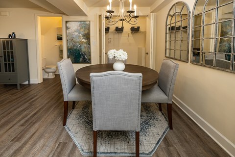 A dining room with a table and chairs.