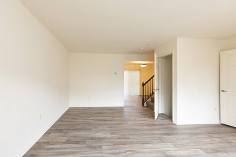 a bedroom with hardwood floors and white walls at Carlson Woods Townhomes, Baltimore