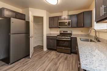 a kitchen with a refrigerator freezer and a stove top oven at Carlson Woods Townhomes, Maryland