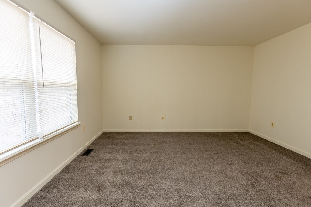 an empty room with carpet and window at Carlson Woods Townhomes, Baltimore, MD, 21244