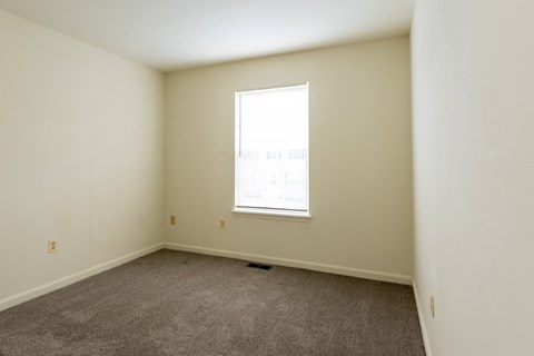 a bedroom with white walls and a window at Carlson Woods Townhomes, Baltimore, Maryland