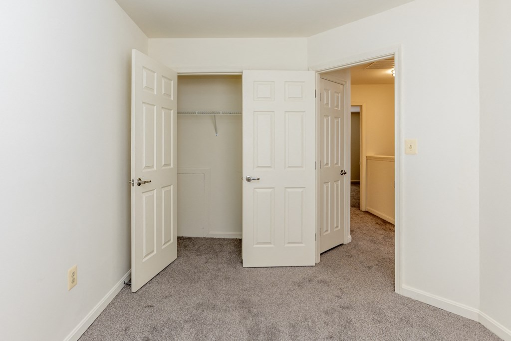 a bedroom with two closets and a carpeted floor at Carlson Woods Townhomes, Baltimore, MD
