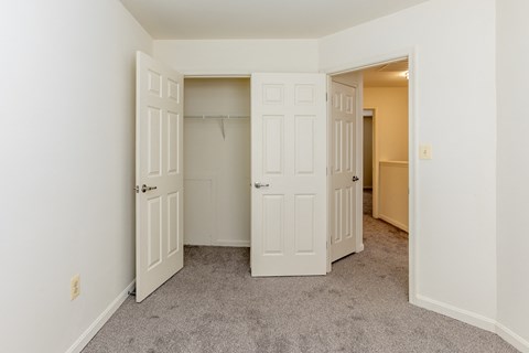 a bedroom with two closets and a carpeted floor at Carlson Woods Townhomes, Baltimore, MD
