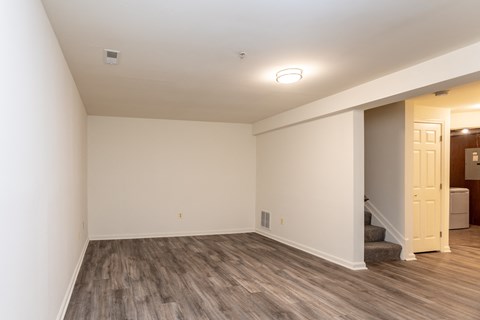 a living room with a hardwood floor and white walls at Carlson Woods Townhomes, Baltimore, Maryland