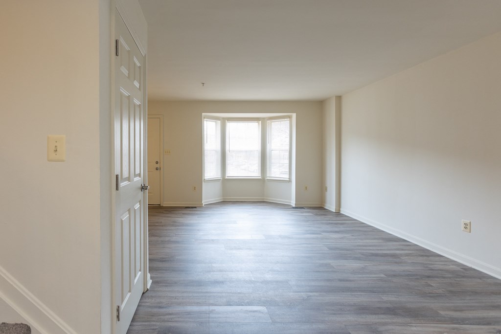 an empty room with white walls and a large window at Carlson Woods Townhomes, Baltimore, MD, 21244