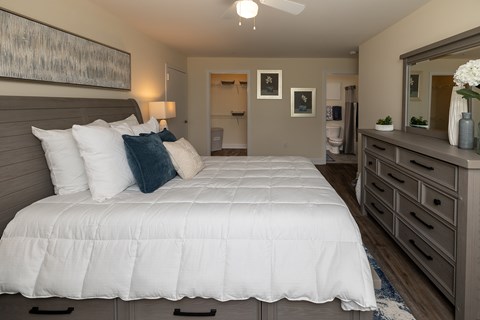 A bedroom with a large bed and a dresser.