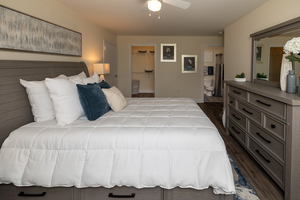 A bedroom with a large bed and a dresser.