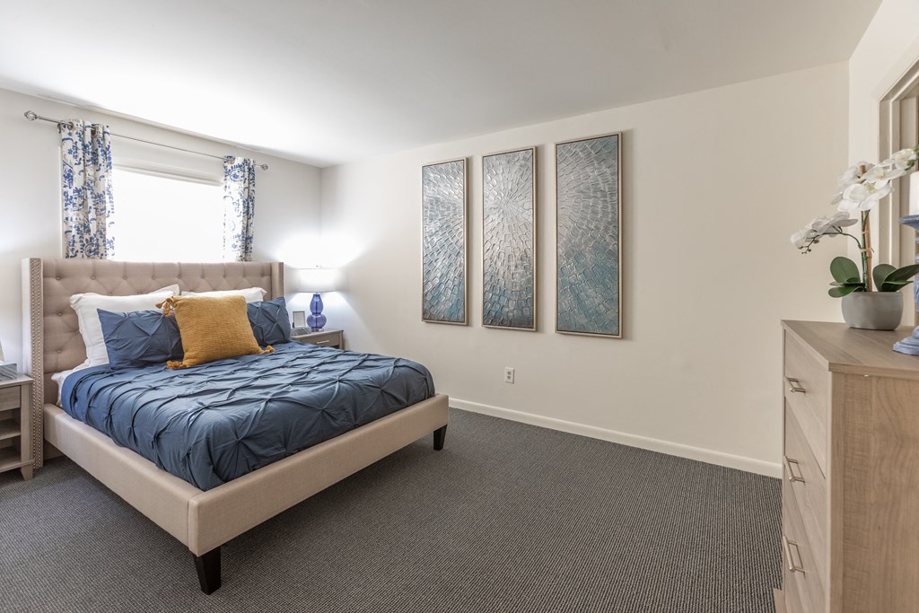 a bedroom with a bed and three paintings on the wall at Lawyers Hill Apartments, Elkridge, MD, 21075