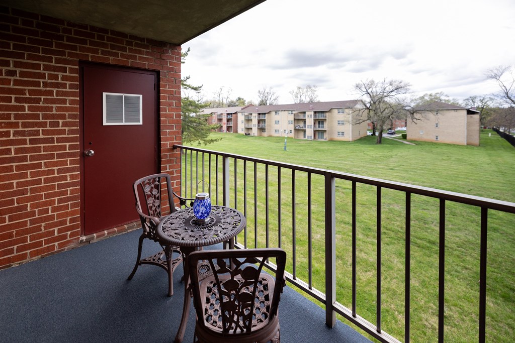 Balcony with two chairs and a table at Rockdale Gardens Apartments*, Baltimore, MD