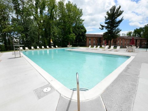A large swimming pool surrounded by trees and chairs at Painters Mill Apartments, Owings Mills, 21117