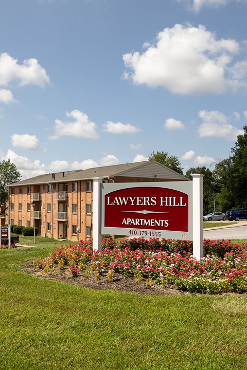 A sign for Lawyers Hill Apartments in front of a building.