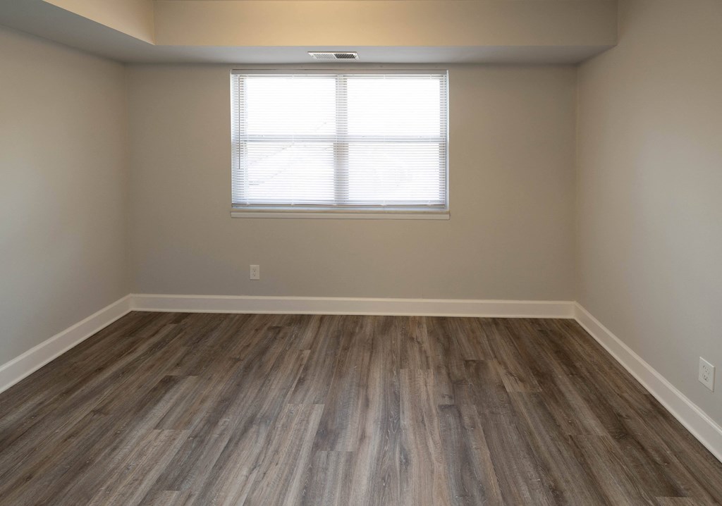 Empty room with hardwood floors and a window at McDonogh Village Apartments & Townhomes, Randallstown, Maryland