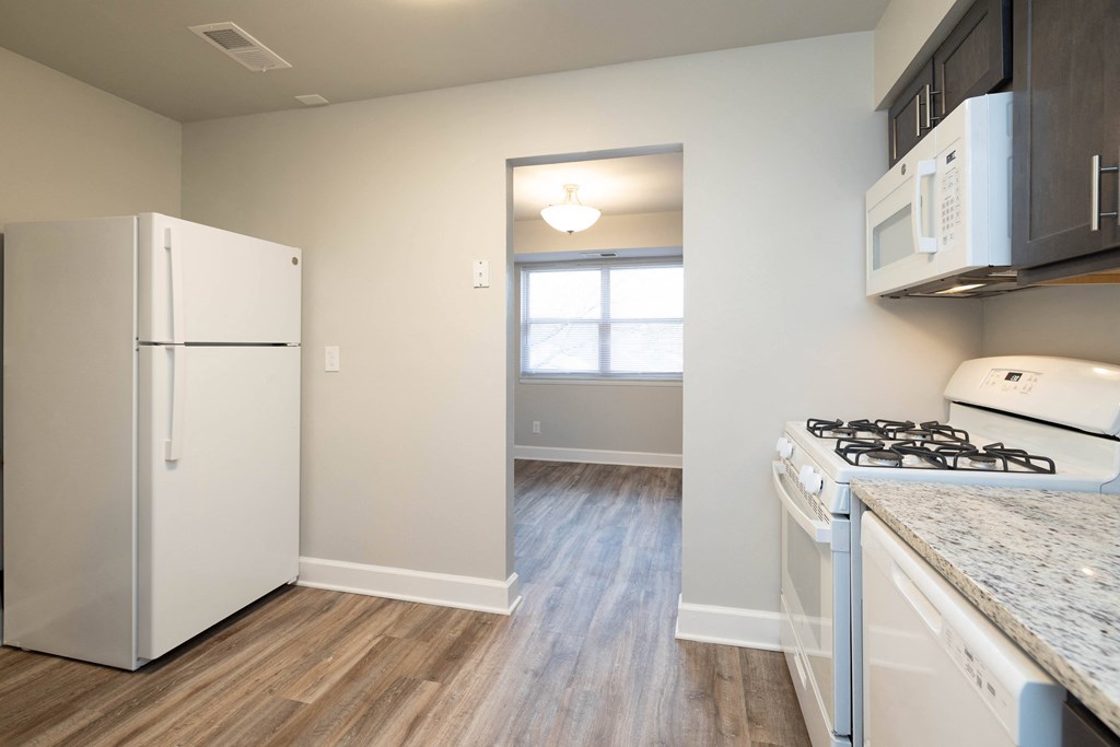 Kitchen with a white refrigerator freezer next to a stove top oven at McDonogh Village Apartments & Townhomes, Randallstown, Maryland, 21133
