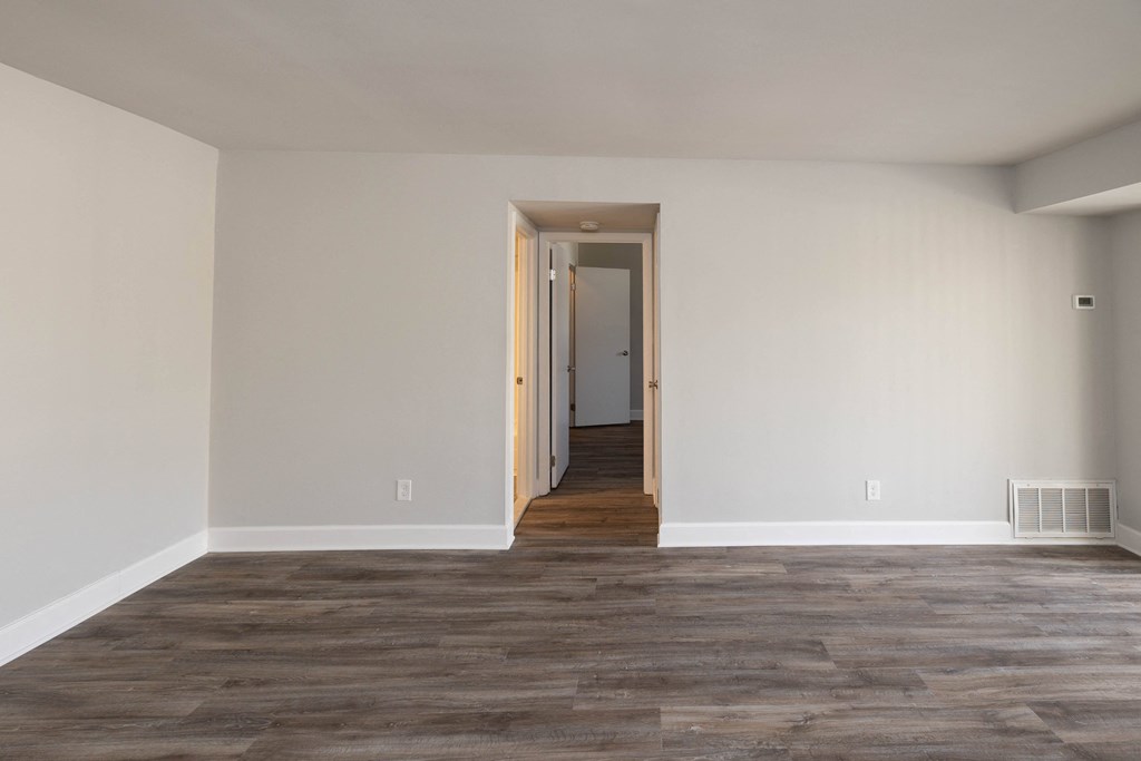 Empty living room with white walls and wood floors at McDonogh Village Apartments & Townhomes, Randallstown, MD, 21133