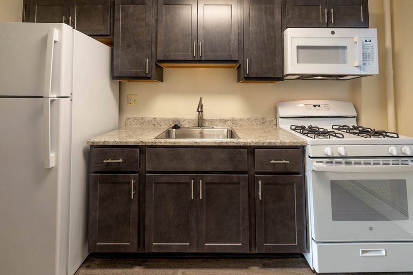 a kitchen with dark wood cabinets and white appliances