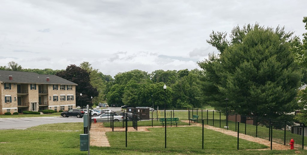 A park with a baseball field and apartment buildings in the background.