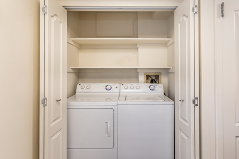 A white washing machine and dryer in a small laundry room.