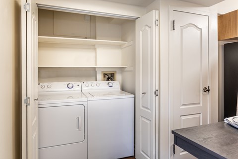 A small laundry room with a washer and dryer in it.
