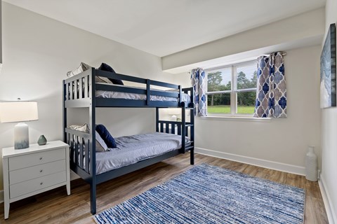 A bedroom with a bunk bed and a dresser.