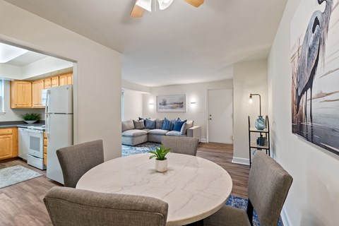 A modern dining room with a round table and chairs at Woodsdale Apartments in Abingdon, MD