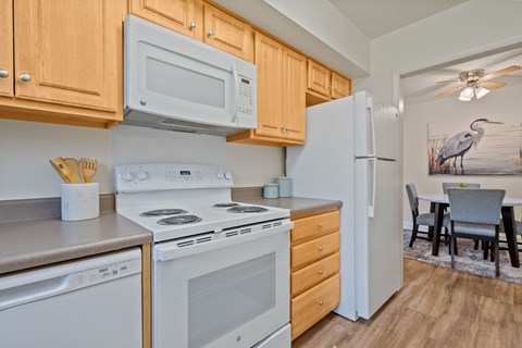 A kitchen with a white stove top oven and white microwave above it at Woodsdale Apartments in Abingdon, MD