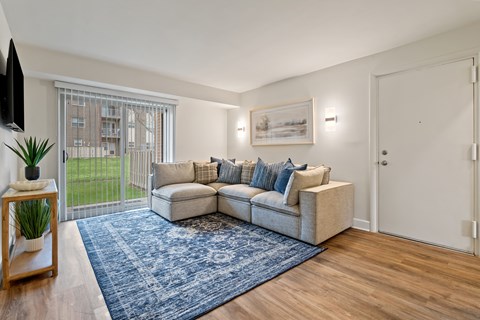 A living room with a couch, a rug, and a television at Woodsdale Apartments in Abingdon, MD
