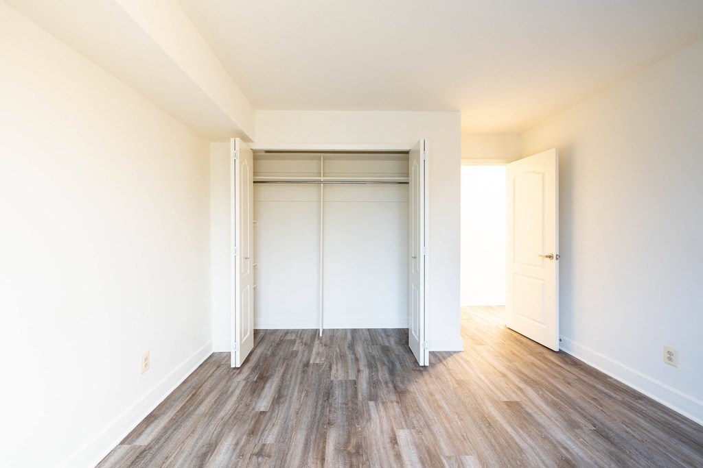 an empty bedroom with white walls and wood floors  at Charlesgate Apartments, Towson, 21204