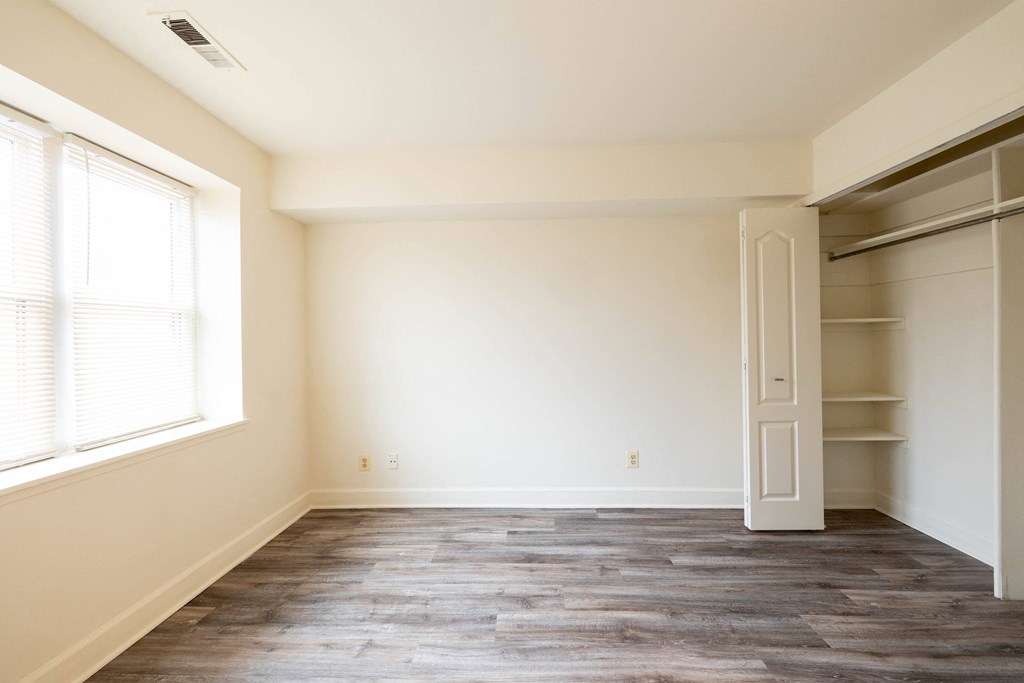 a bedroom with a closet and a window  at Charlesgate Apartments, Towson, Maryland