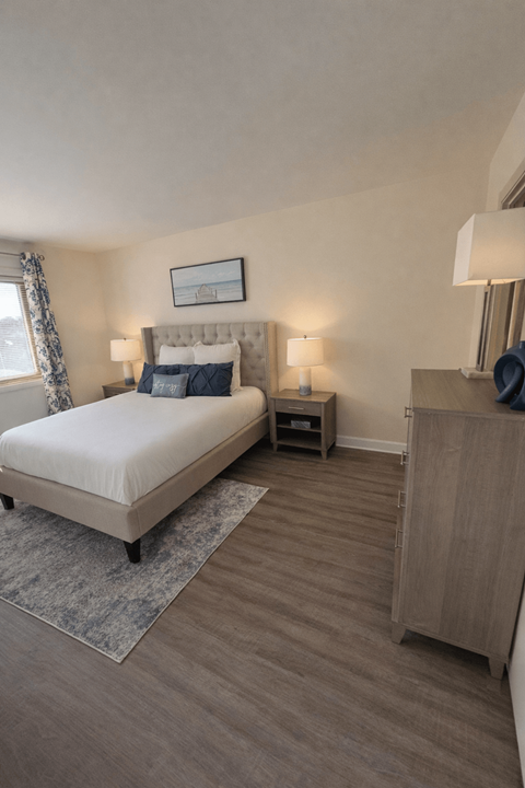 A bedroom with a large bed and a wooden cabinet at Lawyers Hill Apartments, Elkridge, 21075
