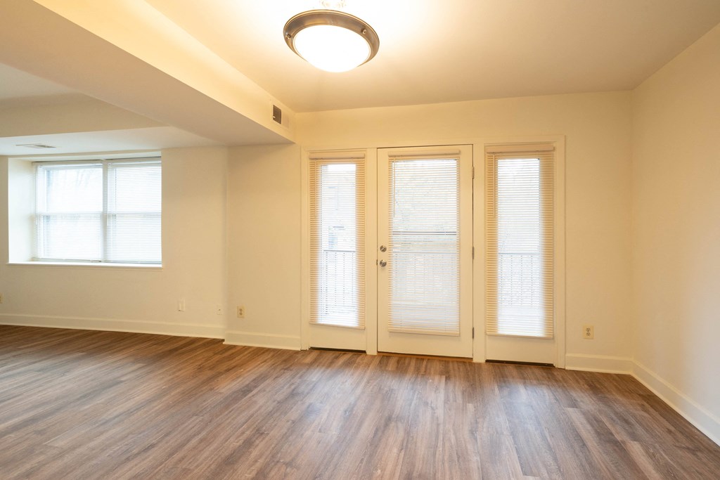 an empty living room with wood floors and french doors  at Charlesgate Apartments, Towson, MD, 21204
