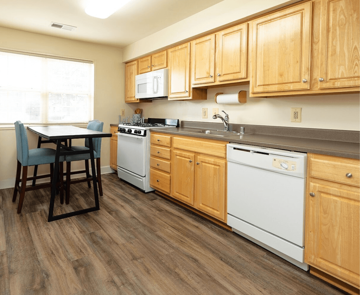 A kitchen with wooden cabinets and a white dishwasher.