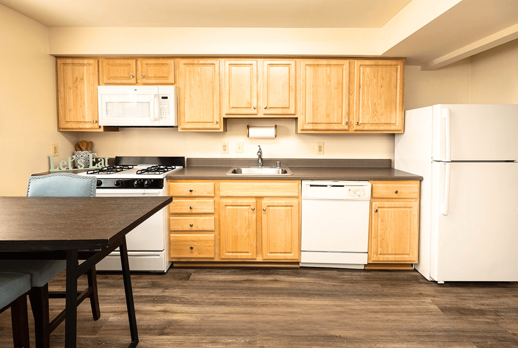 A kitchen with wooden cabinets and white appliances.