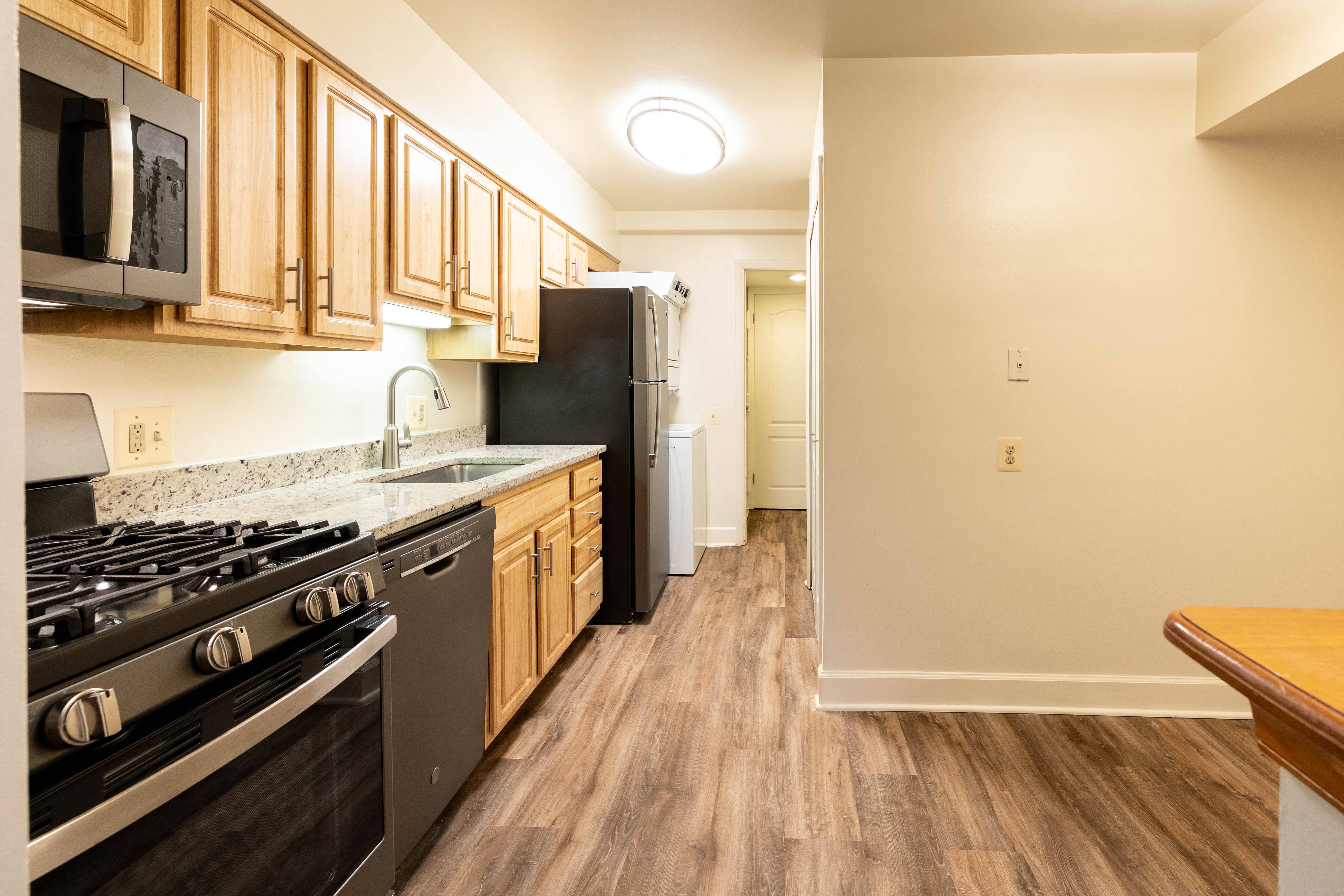 a kitchen with wooden cabinets and stainless steel appliances  at Charlesgate Apartments, Maryland, 21204